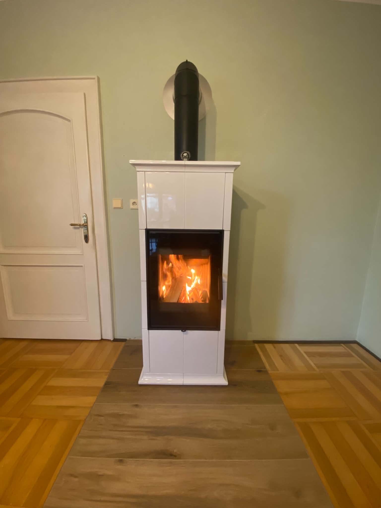 Bílá kachlová kamna s hořícím ohněm